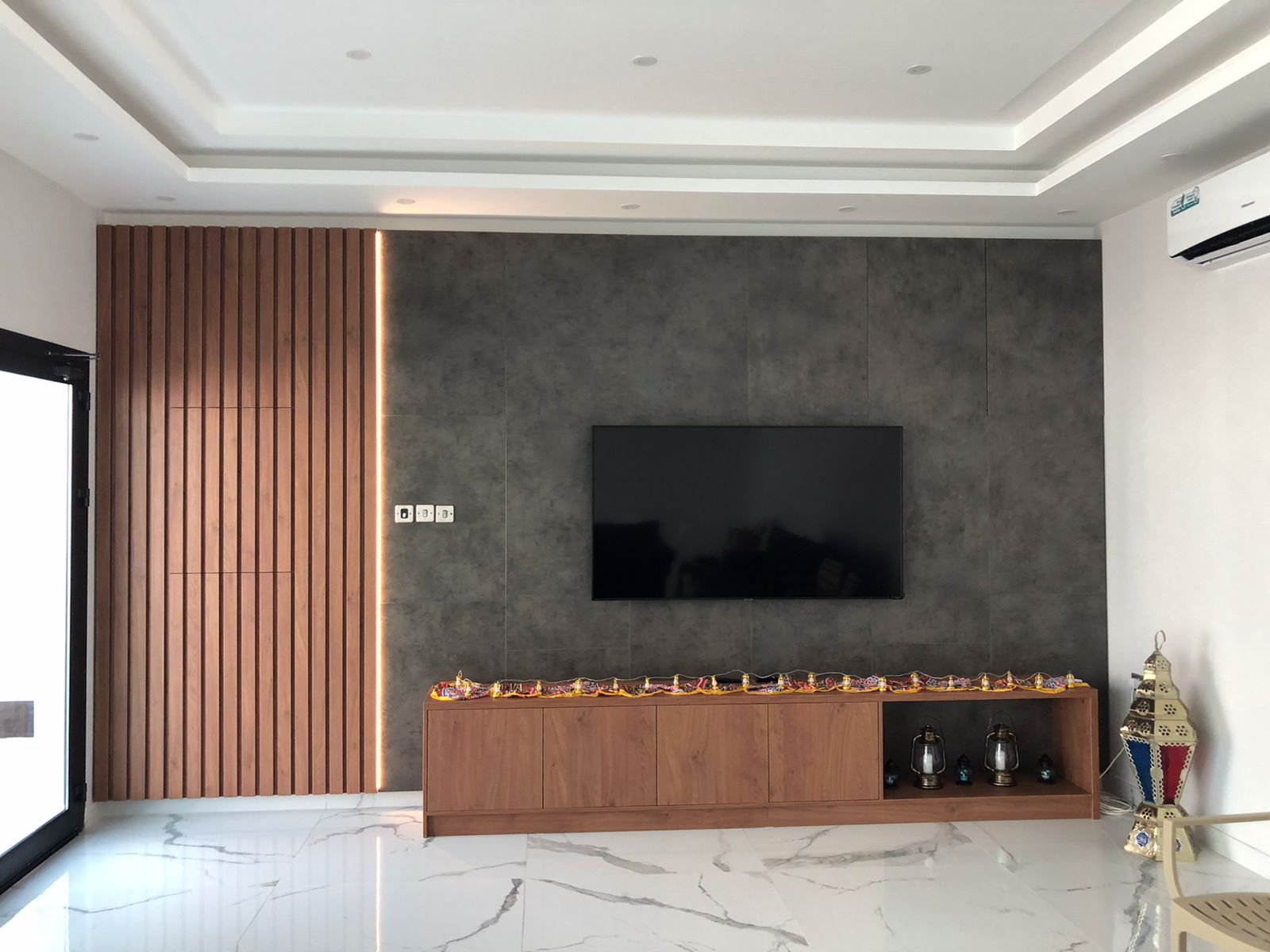 Wall-mounted TV unit with vertical walnut slats and stone panel